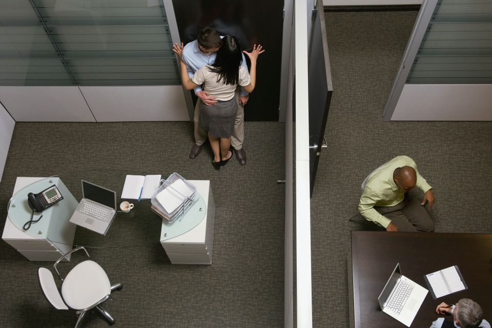 Couple having workplace affair in a office with each other