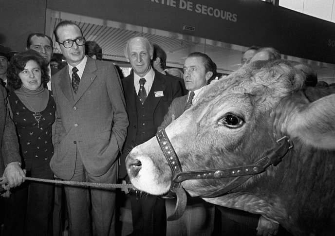 Le premier ministre Jacques Chirac observe un taureau lors de sa visite au salon de l'agriculture, porte de Versailles à Paris le 06 mars 1975. (Photo by STF / AFP)