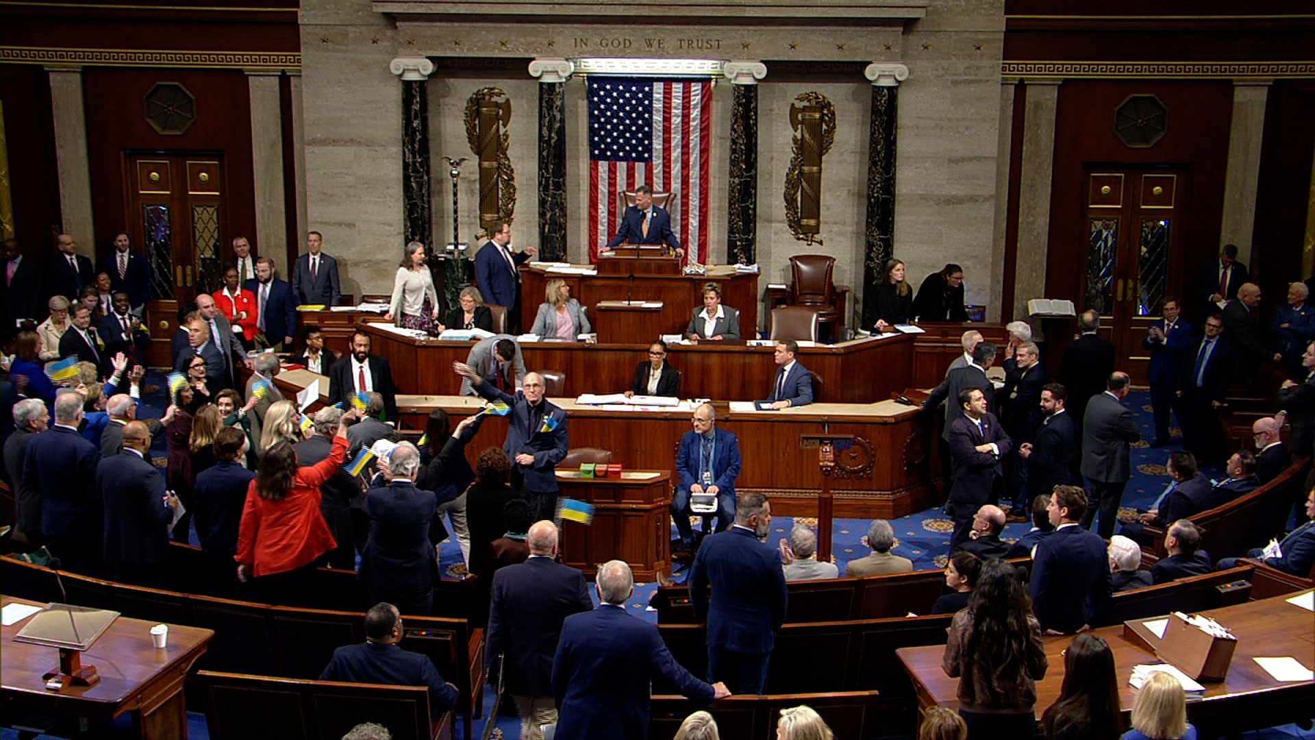 Democratic lawmakers wave Ukrainian flags after the House passed the Ukraine Security Supplemental Appropriations Act. House TV