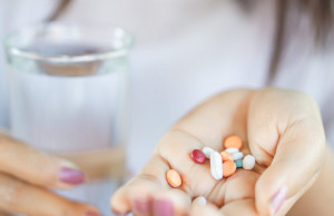woman-hand-taking-vitamins-with-water-scaled-1-1024x643