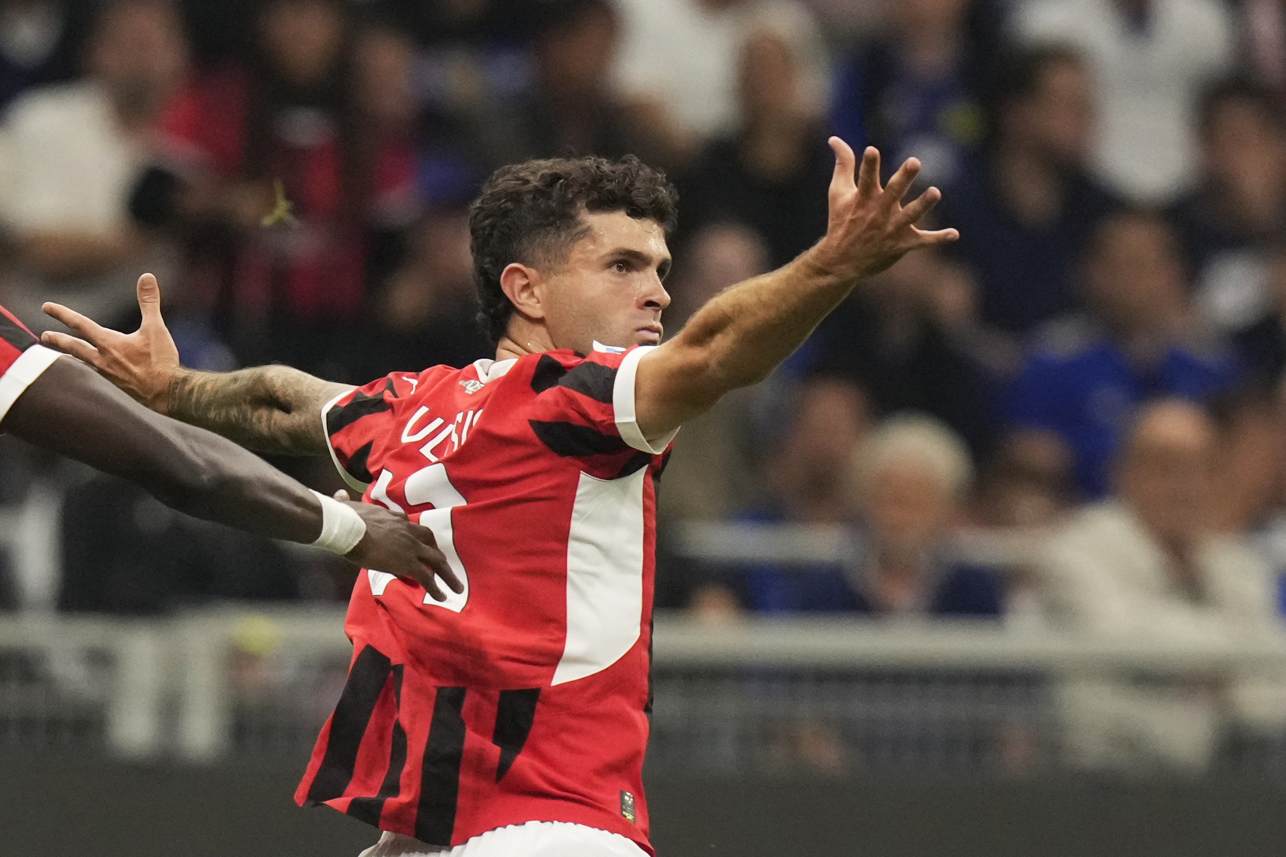 AC Milan's Christian Pulisic celebrates after scoring the opening goal during the Serie A soccer match between Inter Milan and AC Milan at the San Siro stadium in Milan, Italy, Sunday, Sept.22, 2024. (AP Photo/Luca Bruno)