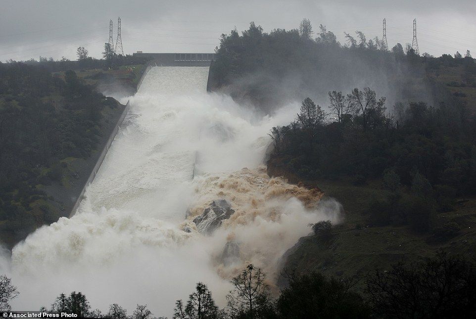 Water flows through break in the wall of the Oroville Dam spillway, Thursday, Feb. 9, 2017, in Oroville, Calif. The torrent chewed up trees and soil alongside the concrete spillway before rejoining the main channel below. Engineers don't know what caused what state Department of Water Resources spokesman Eric See called a "massive" cave-in that is expected to keep growing until it reaches bedrock. (AP Photo/Rich Pedroncelli)