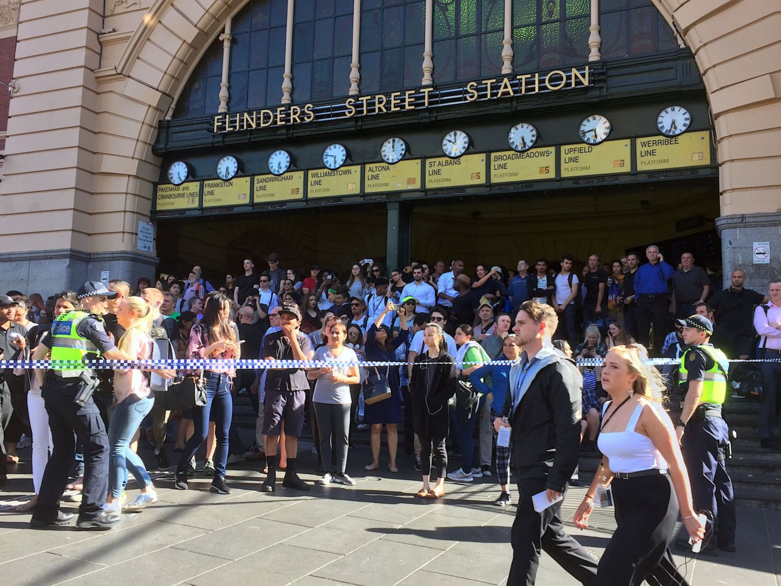 Members of the public stand behind police tape after Australian police said on Thursday they have arrested the driver of a vehicle that ploughed into pedestrians at a crowded intersection near the Flinders Street train station in central Melbourne, Australia December 21, 2017. REUTERS/Melanie Burton