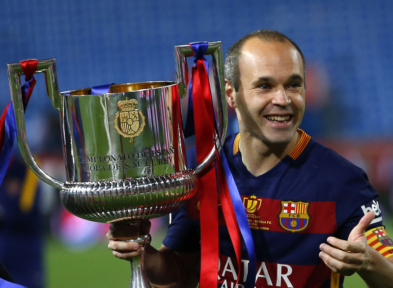 Barcelona's Andres Iniesta carries the trophy after winning the final of the Copa del Rey soccer match between FC Barcelona and Sevilla FC at the Vicente Calderon stadium in Madrid, Sunday, May 22, 2016. Barcelona won 2-0 (AP Photo/Francisco Seco)