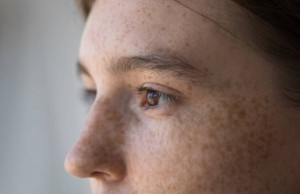 Side profile view face of freckled serious pensive woman staring aside. Close up cropped image of thoughtful young 18s female looking into distance. Concept of vision care, eyesight check up in clinic