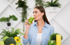 Healthy lifestyle. Woman drinking smoothie, sitting in kitchen, having lunch