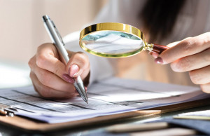 Corporate Auditor Using Magnifying Glass For Tax Fraud Audit